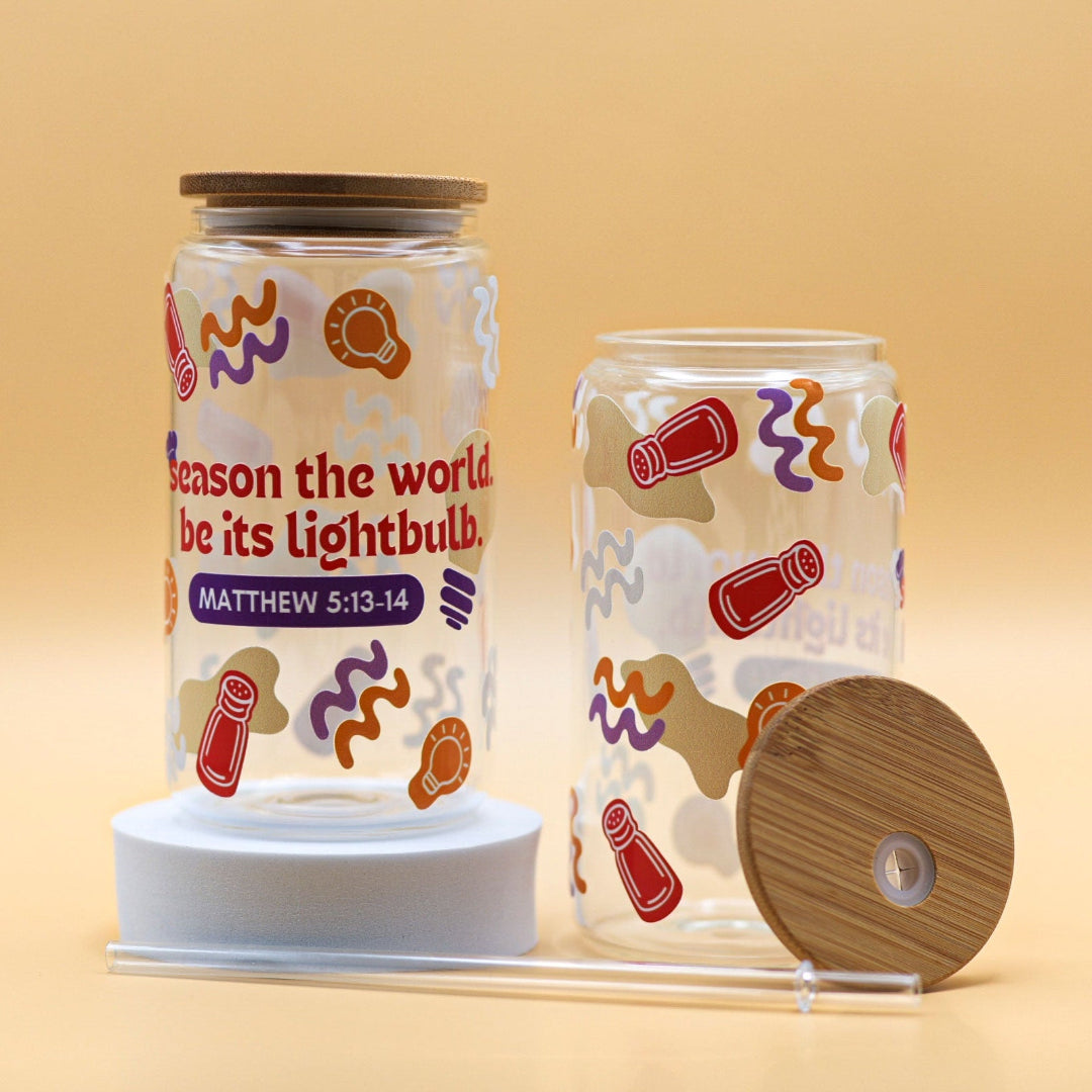Clear glass cup with the phrase ‘Season the world. Be its lightbulb.’ inspired by Matthew 5:13-14, a playful reminder to be salt and light in the world.