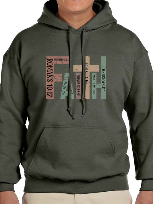 Man wearing a military green hoodie with the word “FAITH” printed in block letters across the chest. Each letter is filled with a Bible verse reference, including Romans 10:17, Ephesians 2:8, Psalm 37:5, Proverbs 3:5–6, John 3:16, Matthew 21:22, and Hebrews 11:1. The design combines bold typography and scripture for a powerful, faith-centered statement.