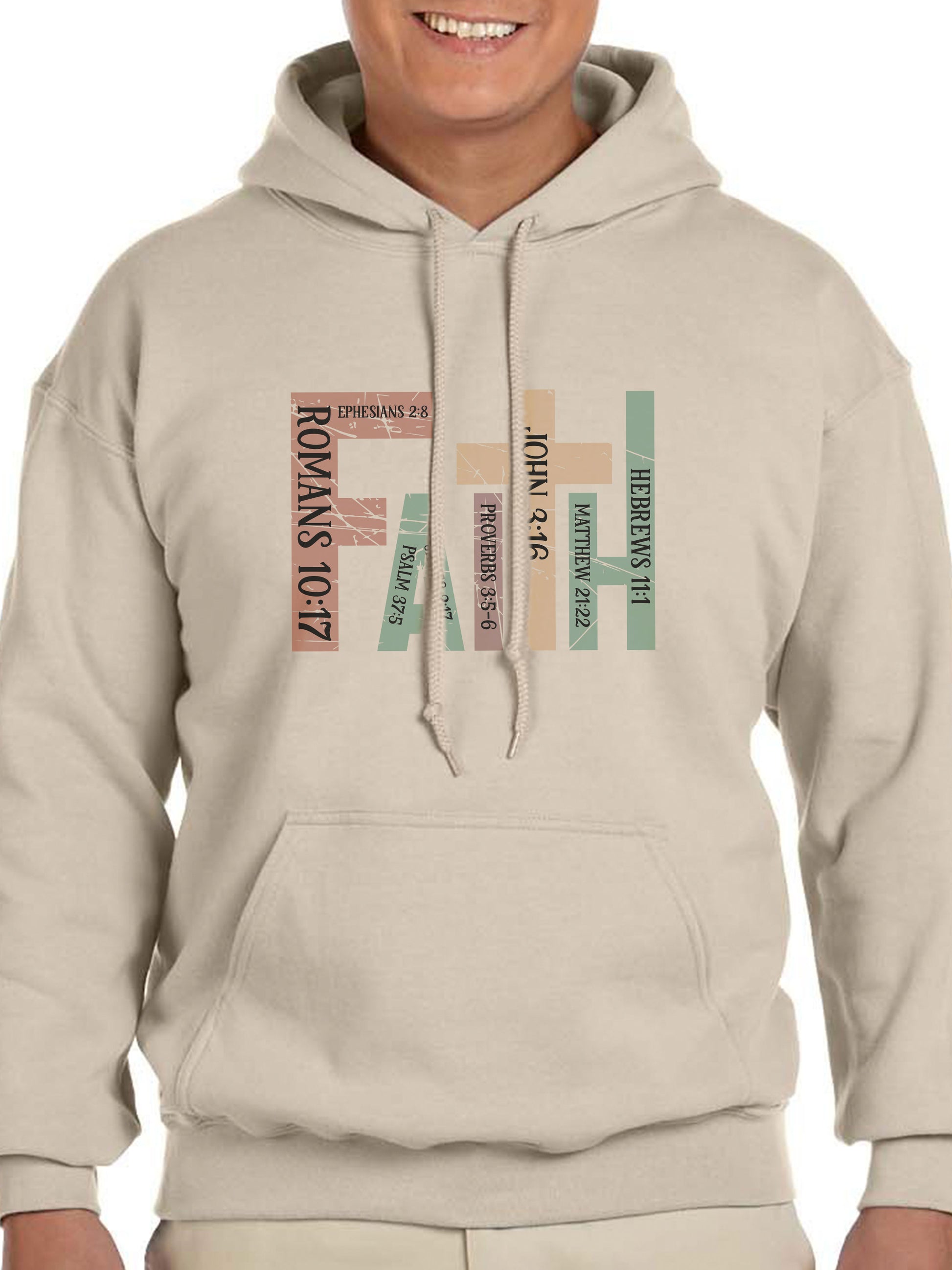 Man wearing a sand hoodie with the word “FAITH” printed in block letters across the chest. Each letter is filled with a Bible verse reference, including Romans 10:17, Ephesians 2:8, Psalm 37:5, Proverbs 3:5–6, John 3:16, Matthew 21:22, and Hebrews 11:1. The design combines bold typography and scripture for a powerful, faith-centered statement.
