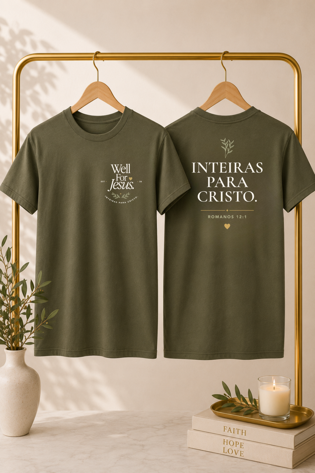 Two olive green graphic T-shirts hanging on a gold clothing rack, showing the front and back designs. The front reads 'Well For Jesus' with decorative text, and the back reads 'INTEIRAS PARA CRISTO' with a small heart and floral detail.