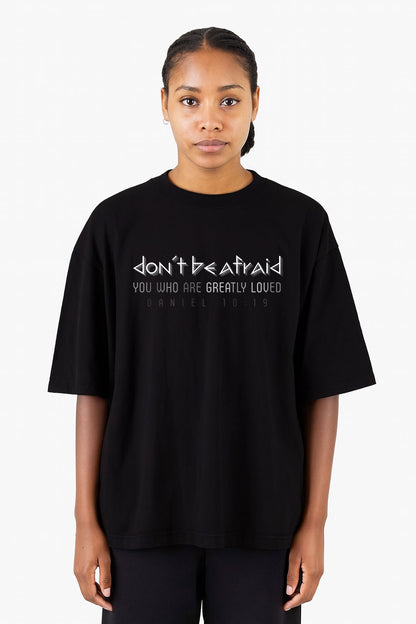 Woman wearing a black oversized heavyweight Christian t-shirt with the phrase “Don’t Be Afraid, You Who Are Greatly Loved” from Daniel 10:19
