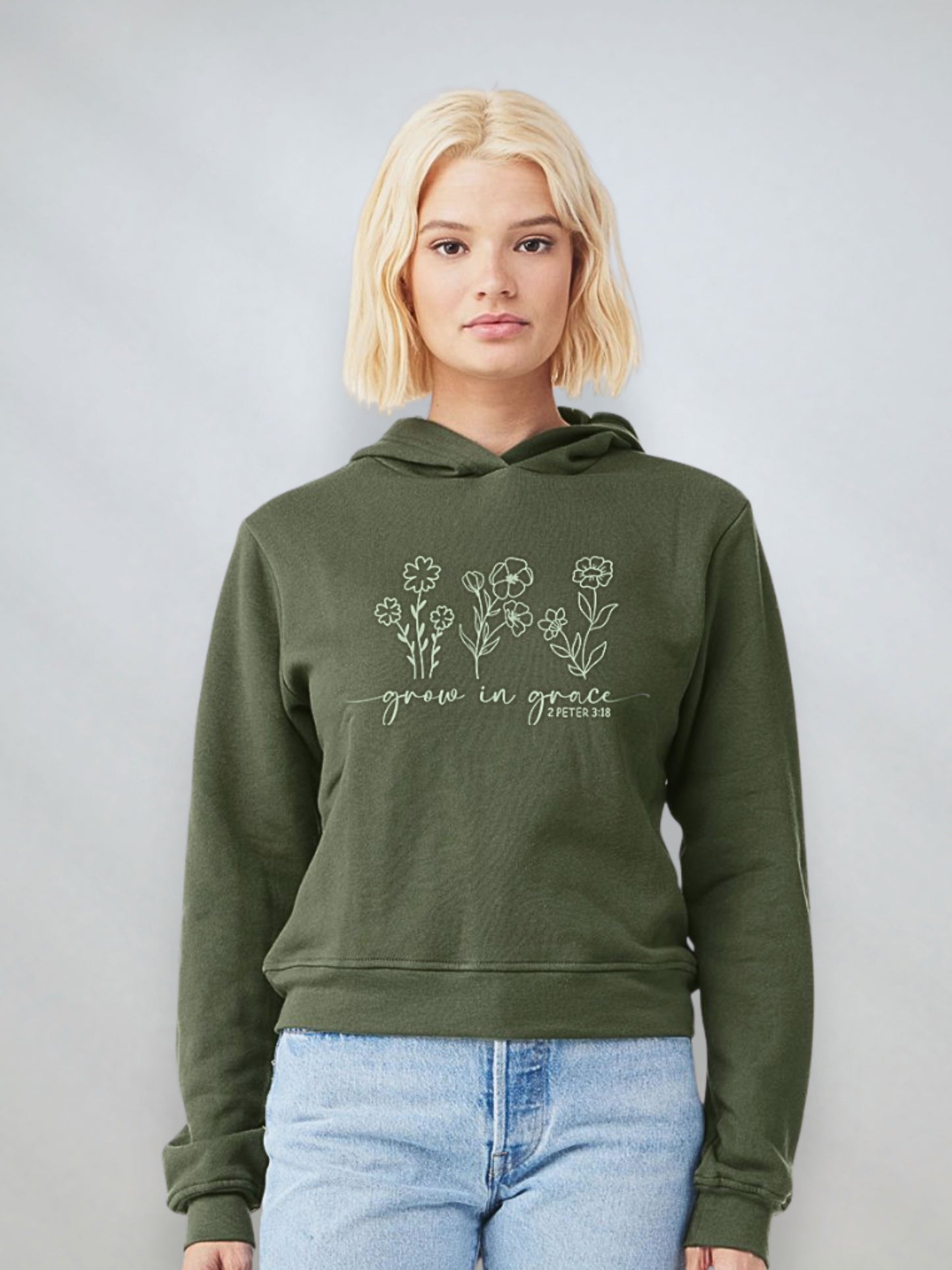 Woman wearing a military green Christian hoodie with floral design and the phrase “Grow in Grace” from 2 Peter 3:18