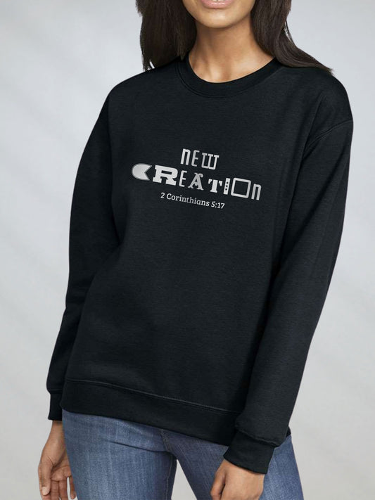 Woman wearing black sweatshirt with “New Creation – 2 Corinthians 5:17” text