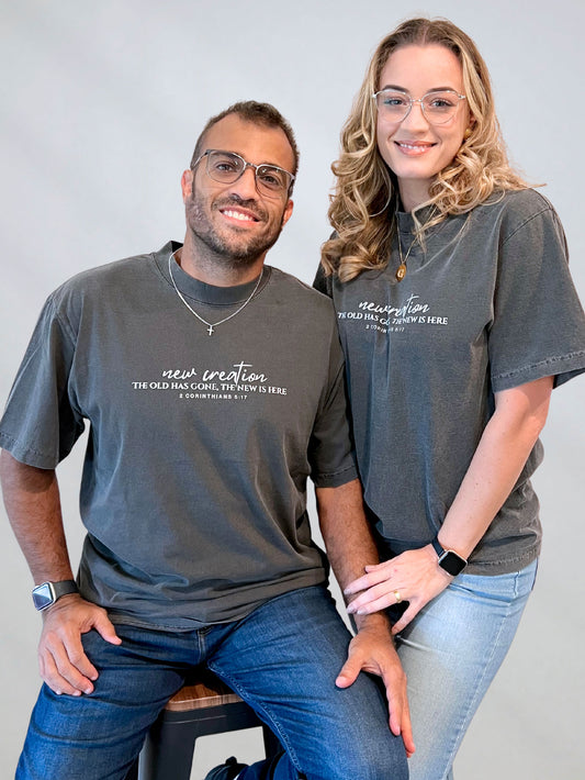 “Couple wearing the New Creation garment-dyed Christian tee with 2 Corinthians 5:17 on the front.”