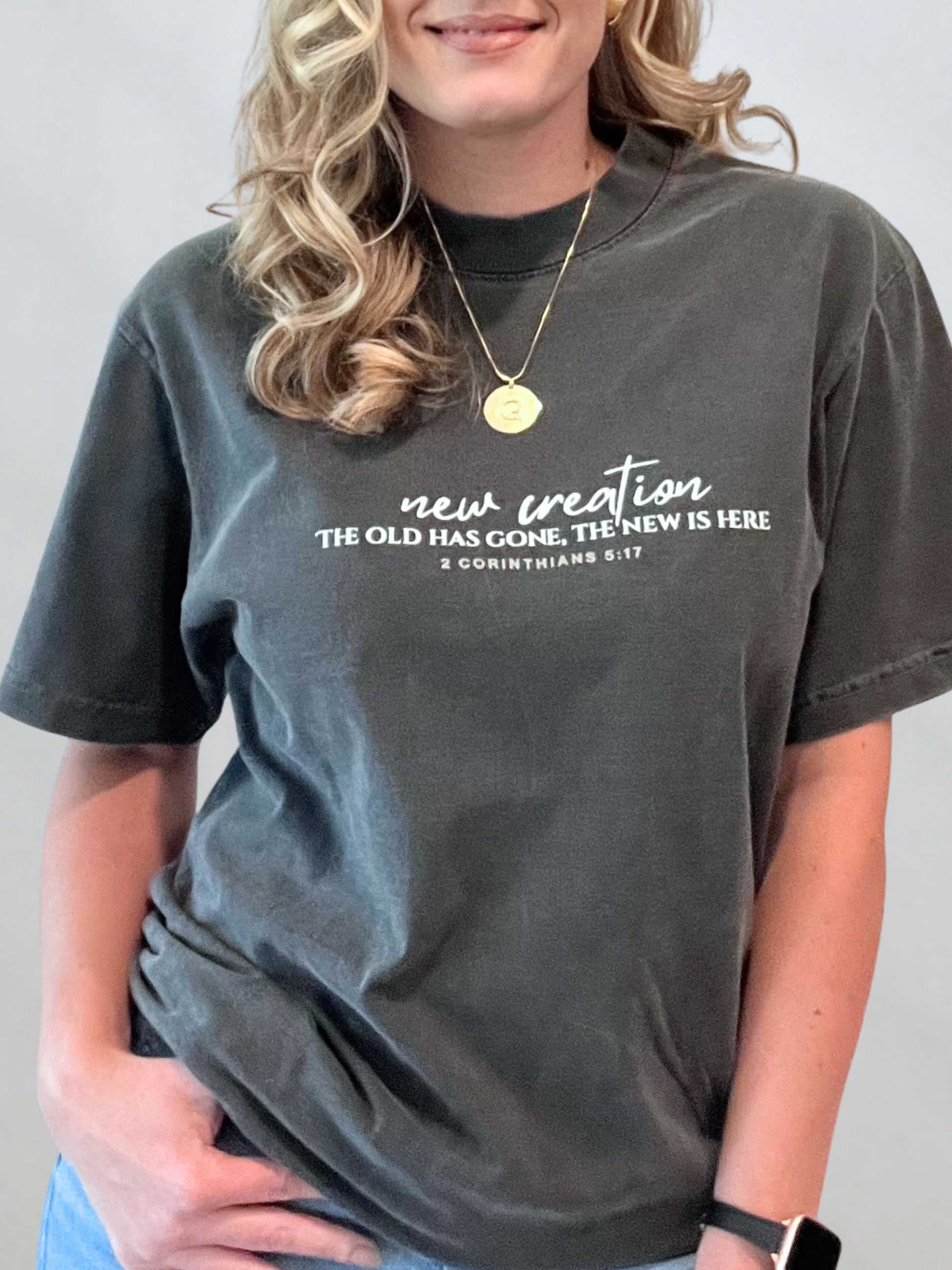 Female model in the New Creation garment-dyed tee highlighting 2 Corinthians 5:17