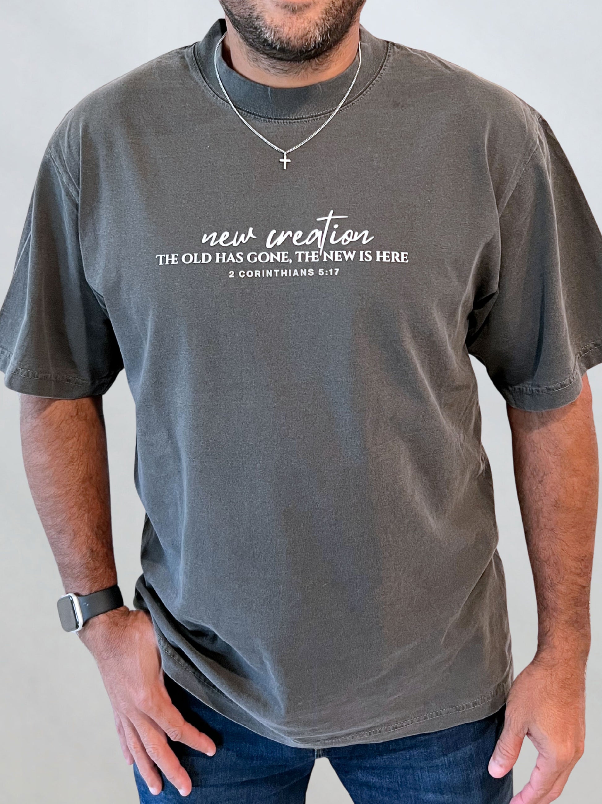 Male model wearing the heavyweight garment-dyed New Creation tee with ‘new creation’ chest script