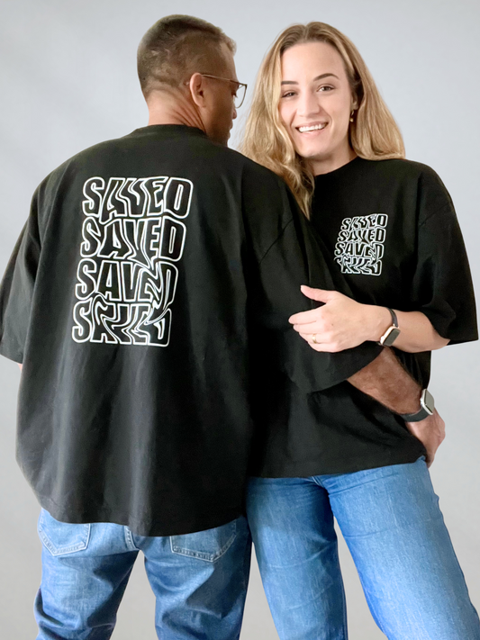 Couple wearing black oversized SAVED drop shoulder tee with bold front and back print