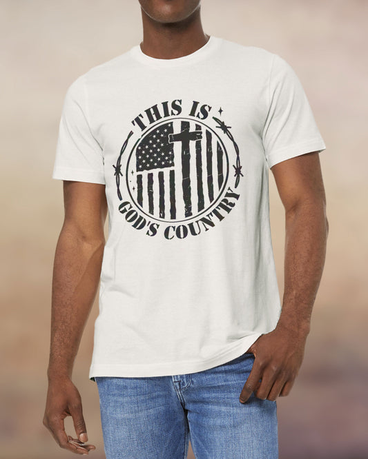 Christian men’s t-shirt in vintage white with a black distressed American flag and cross design that says “This Is God’s Country.”